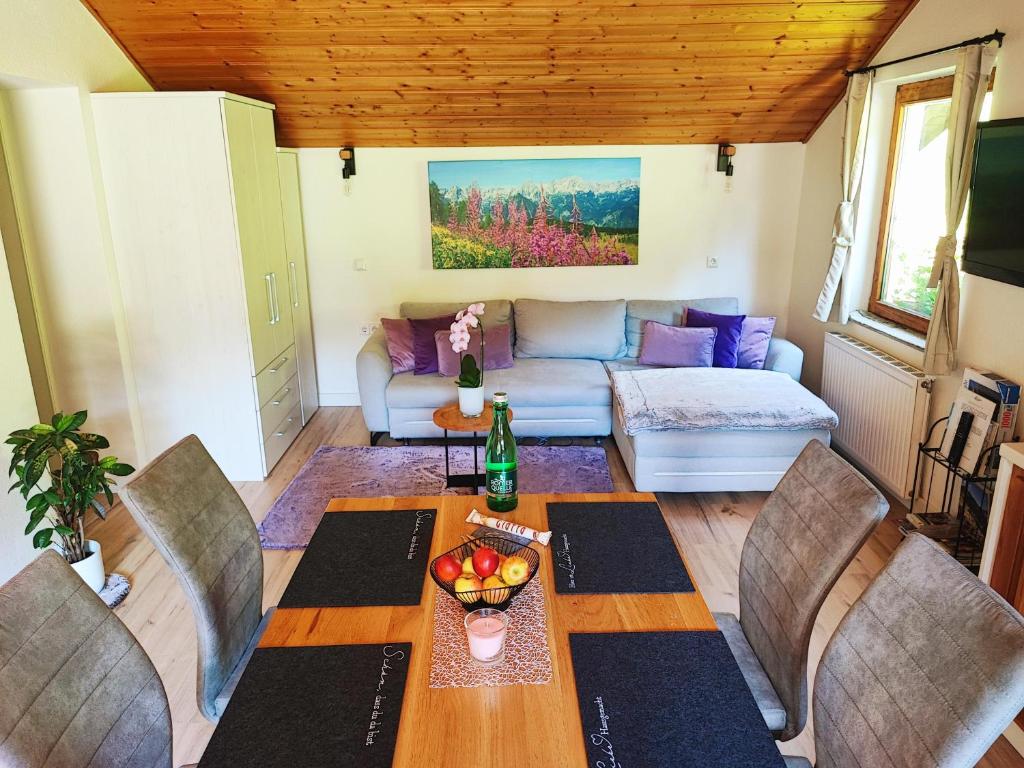 un soggiorno con tavolo, sedie e divano di Villa Bischofsberg - Lärchen-Wellness Apartment a Windischgarsten