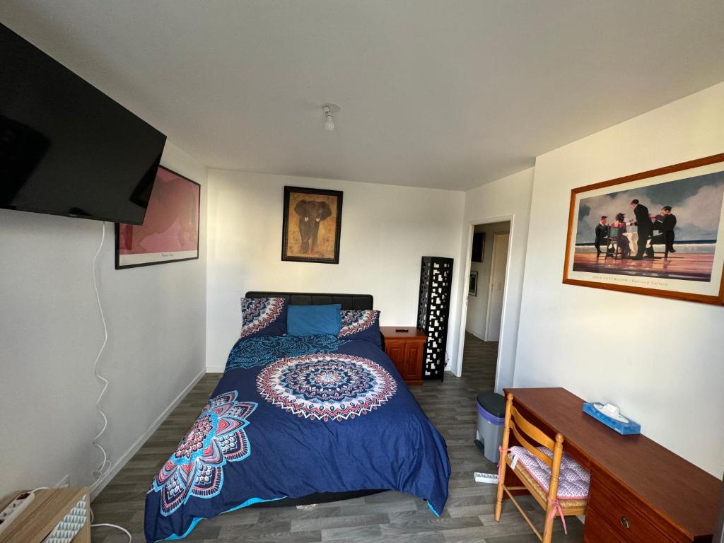 a bedroom with a bed and a desk and a television at Jolie chambre à Nanterre Préfecture proche La Défense Aréna Campus SNCF et Paris in Nanterre