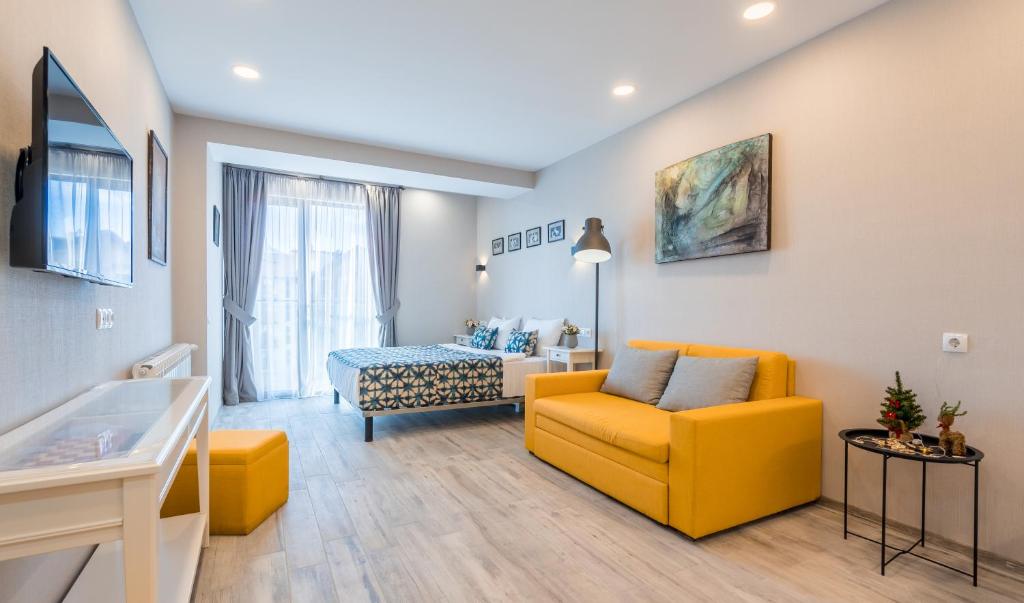 een woonkamer met een gele stoel en een bank bij Lolo Apartment in Goedaoeri