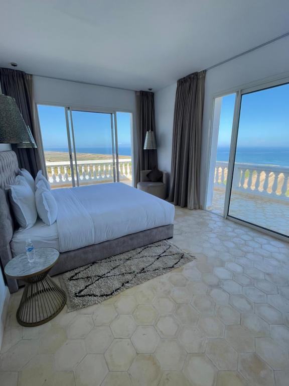 a bedroom with a bed and views of the ocean at Villa La Falaise in Oualidia