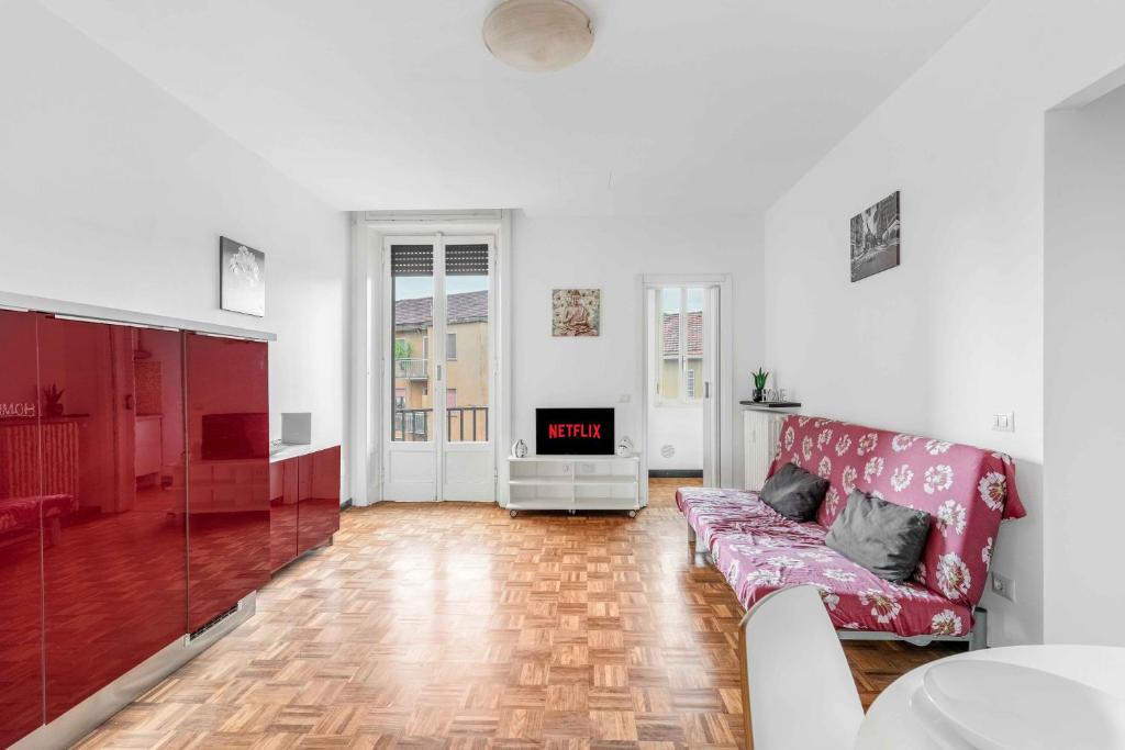 een woonkamer met een rode bank en een open haard bij MI8 -10 minutes from the Duomo- Large Apartment in Milaan