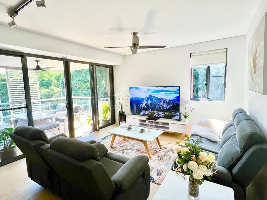 a living room with a couch and a tv at Luxury Waterfront Apartment (2 bedrooms) in Darwin