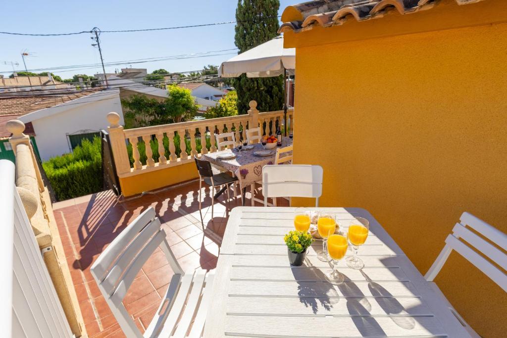 a table with two glasses of orange juice on a balcony at Marina Blue by Fidalsa in La Marina