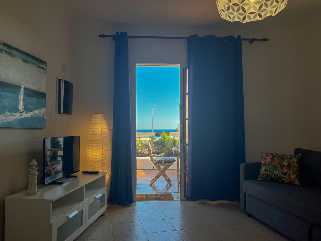 ein Wohnzimmer mit einer Tür, die auf eine Terrasse führt in der Unterkunft Amazing Apartment Altamar 2 in Playa del Aguila