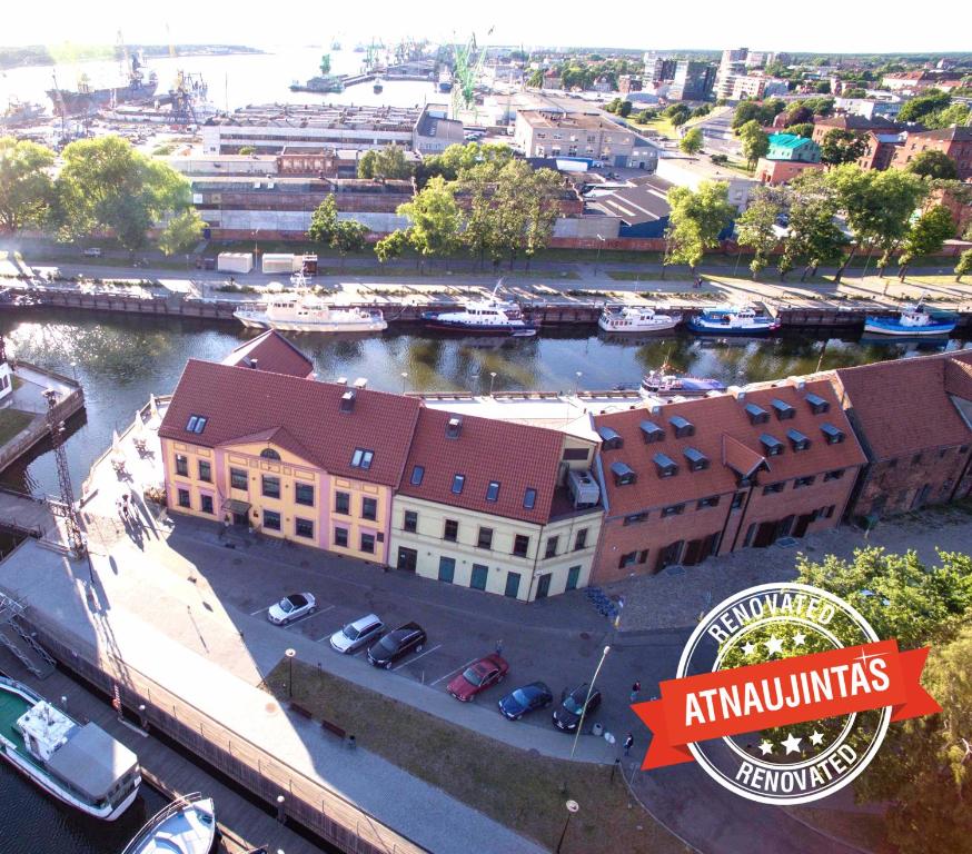 an aerial view of a building and a river with boats at Old Mill Conference in Klaipėda