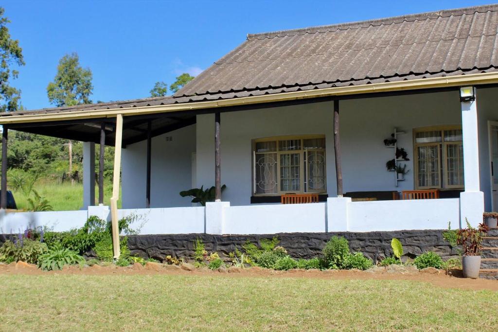 Umtali的住宿－Lovely 4 bed in Mutare - 2178，白色房子,有棕色的屋顶