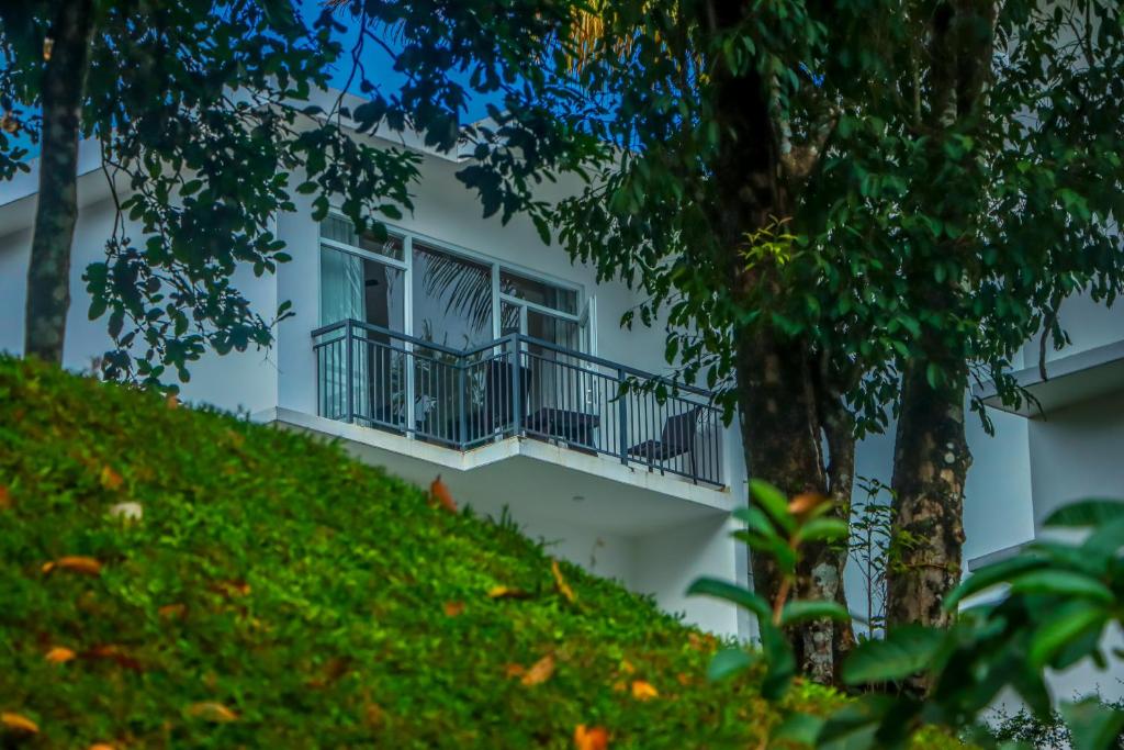 a white building with a balcony on a hill at Winter Note Resorts in Munnar