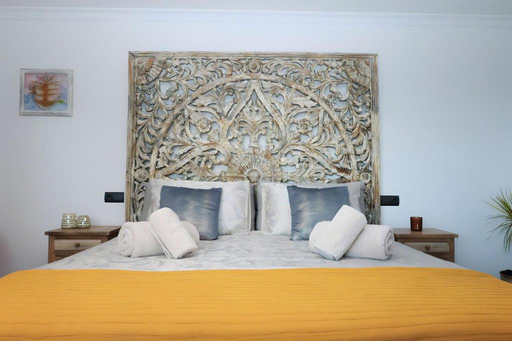 a bedroom with a large bed with a gold headboard at La Pina Verde in Estepona