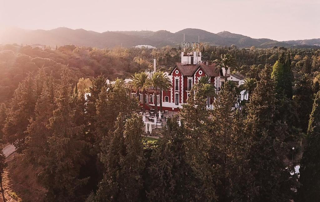 a large building in the middle of a forest of trees at Hotel Finca Los Abetos in Córdoba