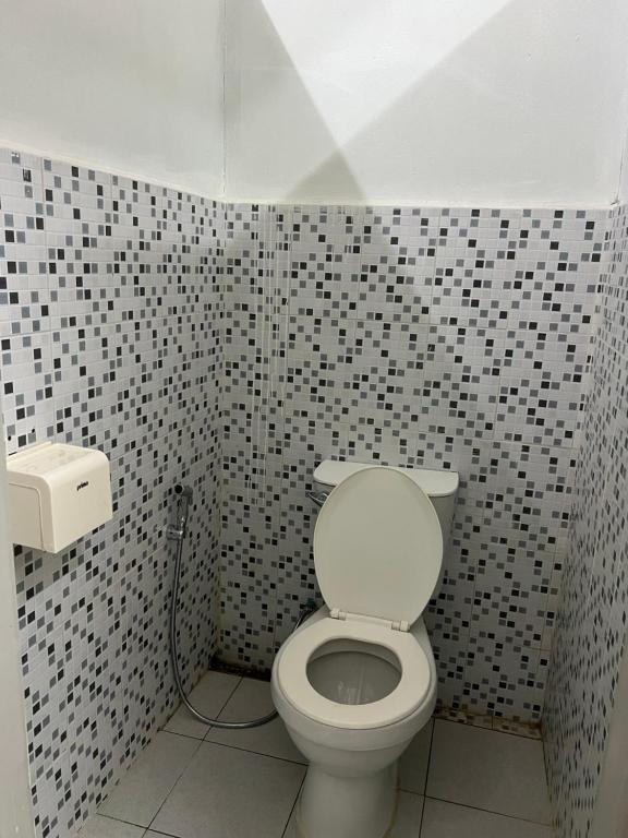 a bathroom with a toilet and black and white tiles at Hostel in Phra Ae beach
