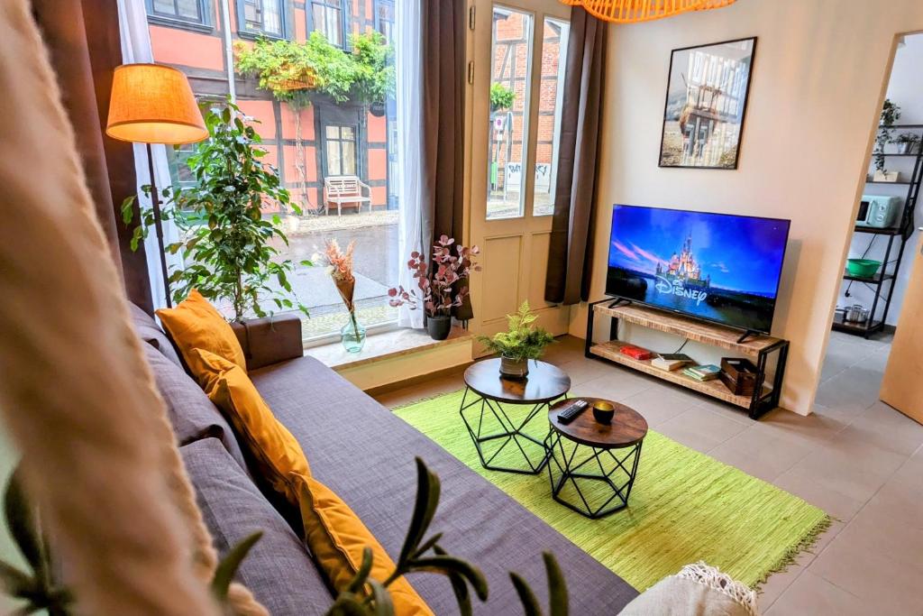 uma sala de estar com um sofá e uma televisão em Uhlpartment - im Herzen von Salzwedel em Salzwedel