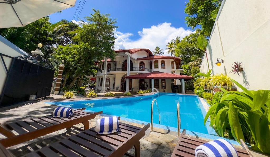 a swimming pool in front of a house at Wisdom Boutique Resort in Kandy