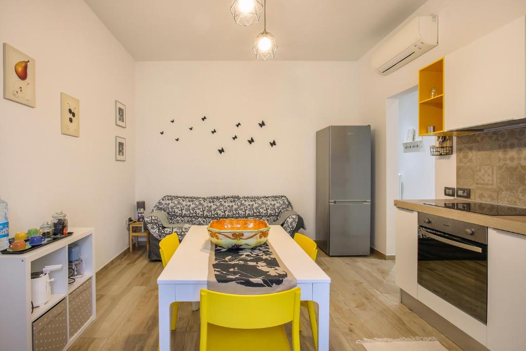 eine Küche und ein Wohnzimmer mit einem Tisch und gelben Stühlen in der Unterkunft HOUSE 46 in Florenz