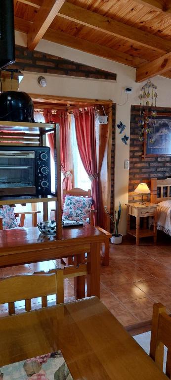 1 dormitorio y sala de estar con mesa de comedor. en Lejana Patagonia en Esquel