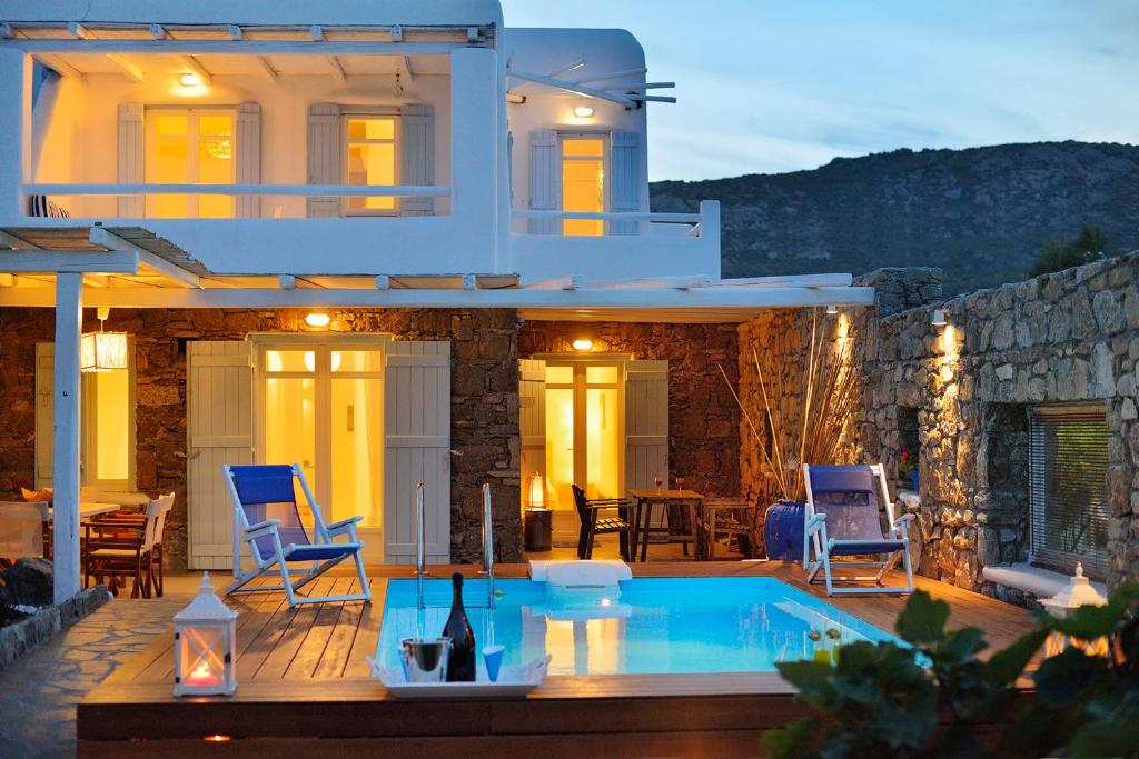 a villa with a swimming pool in front of a house at Villa Princess 1 4Bed with Pool Panormos Beach in Panormos Mykonos