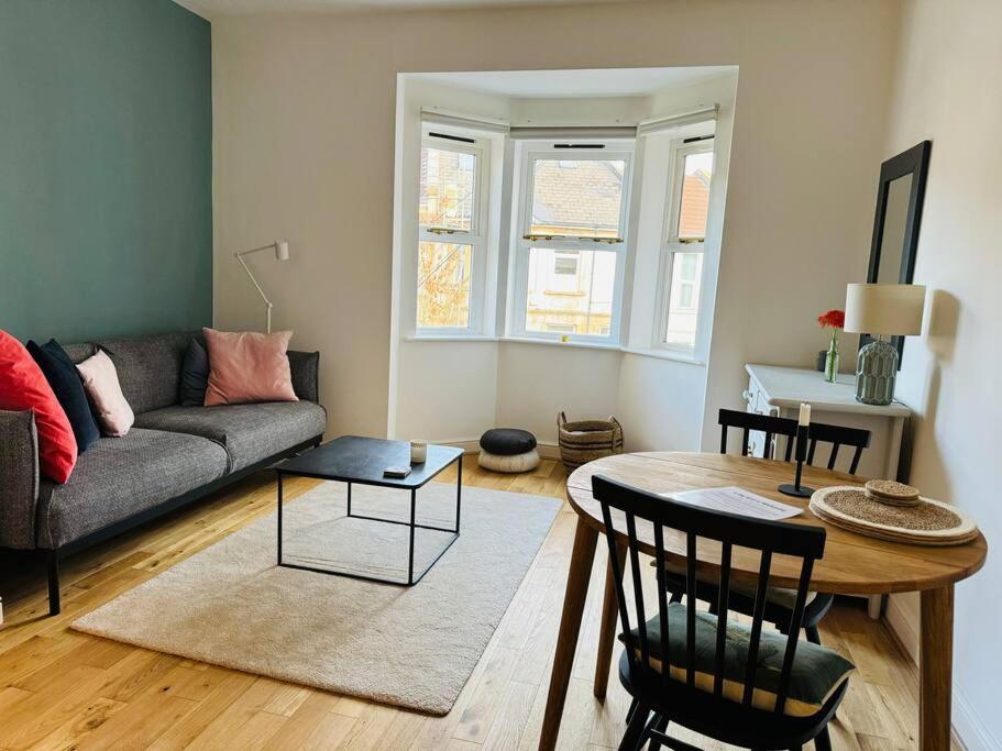 a living room with a couch and a table at Stylish city flat with private parking in Bristol