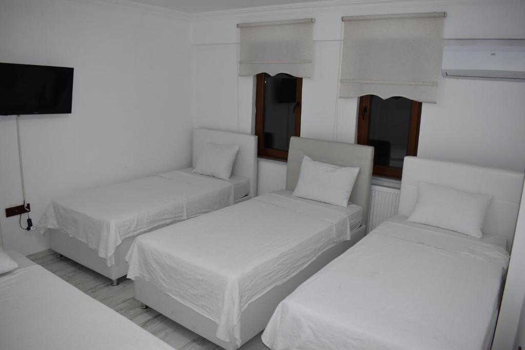 a room with two beds and a flat screen tv at edr ulus 22otel in Edirne