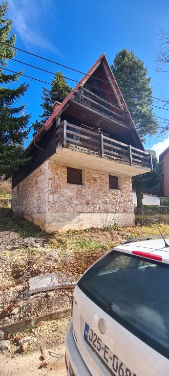 a building with a car parked in front of it at Vjeverica Chalet in Jahorina