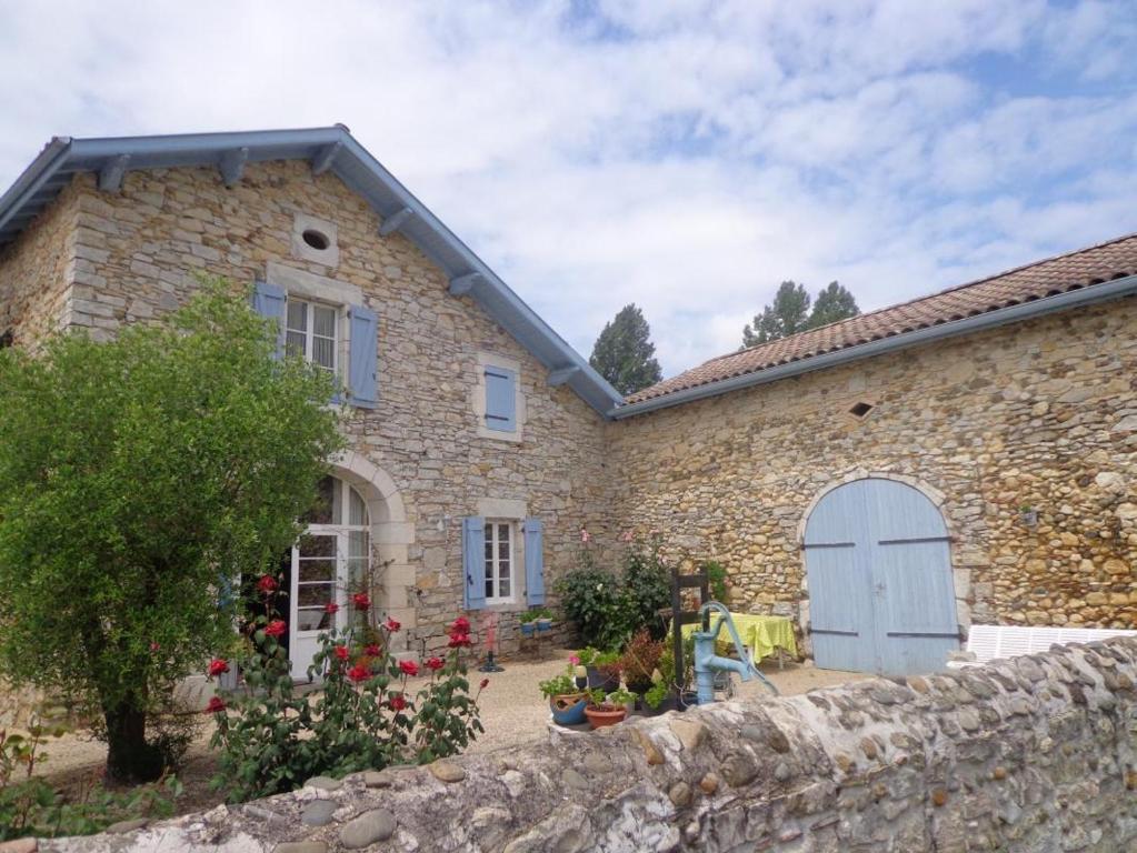 una casa in pietra con un muro di pietra di Gite de spalette a Orthevielle