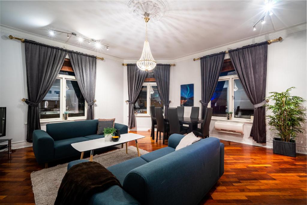 een woonkamer met blauwe banken en een tafel bij Enter Tromsø Ultimate Luxury - Jacuzzi & Sauna in Tromsø