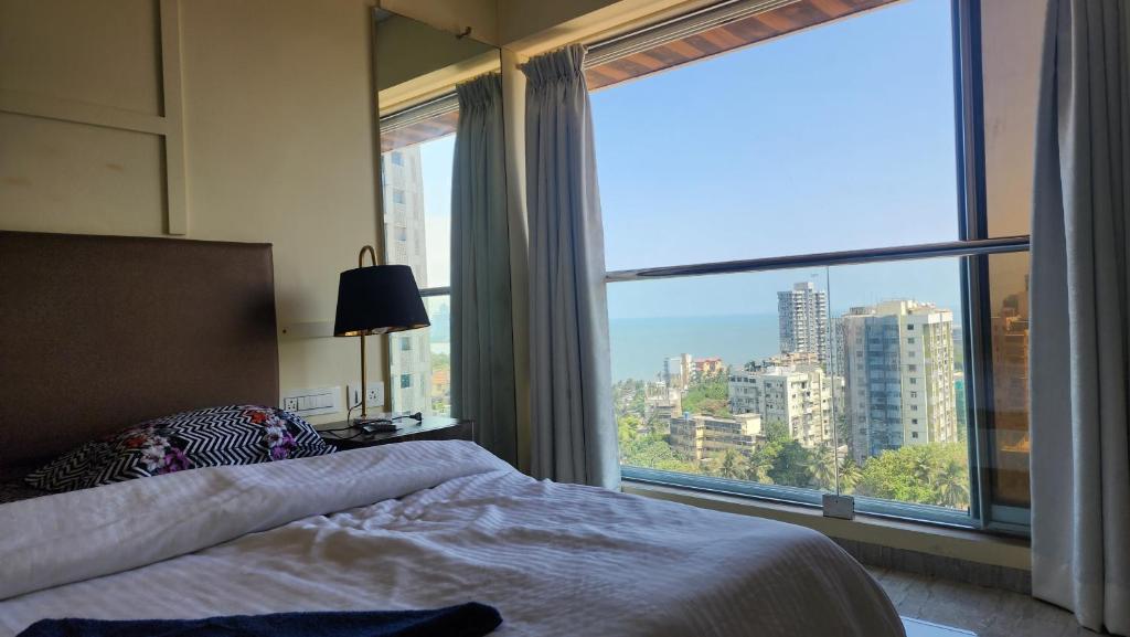 a bedroom with a bed and a large window at Ocean 360 in Mumbai