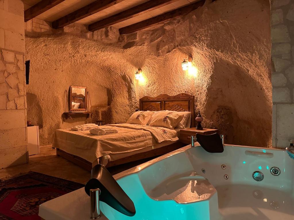 een slaapkamer met een bed en een bad bij Kale House Nar in Nevsehir