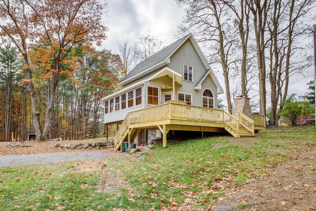 a house with a large deck on a field at Rustic Retreat Walk to Great Sacandaga Lake! in Broadalbin