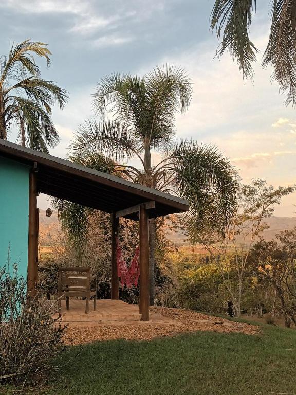 a pavilion with a bench and palm trees at Pousada & Chalés Quinta da Nascente - Serra da Canastra in Delfinópolis
