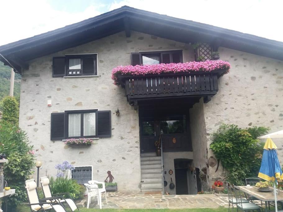 ein Haus mit einem Balkon mit Blumen darauf in der Unterkunft Casa Colori (C.I.R. 014051) in Poggiridenti