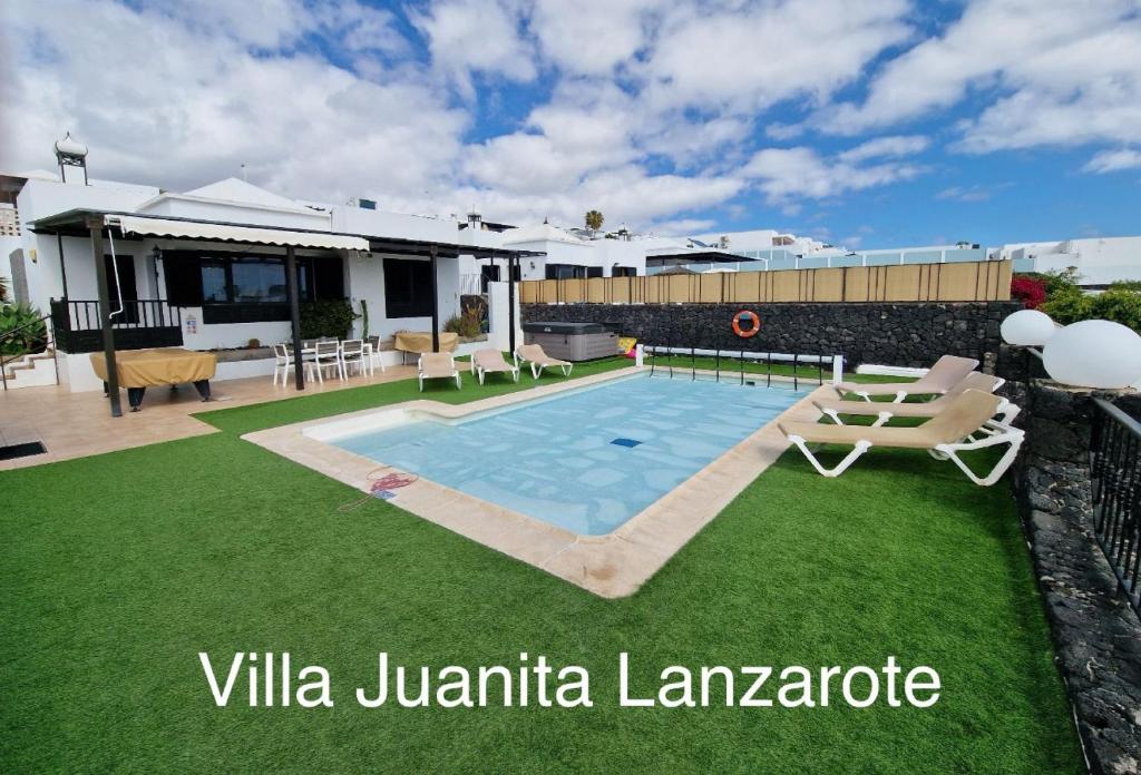 uma villa com uma piscina e uma casa em Villa Juanita, Puerto del Carmen, Lanzarote em Tías