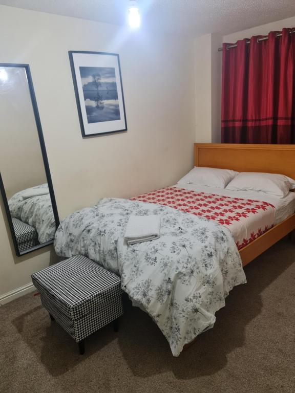 sypialnia z łóżkiem i lustrem w obiekcie Curly Curves w mieście North Woolwich