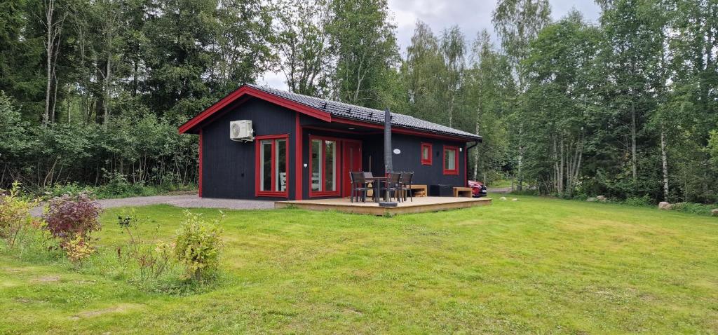 una casita roja y azul en un patio en Nygård Cabins - brandnew holiday home with 3 bedrooms en Sunne