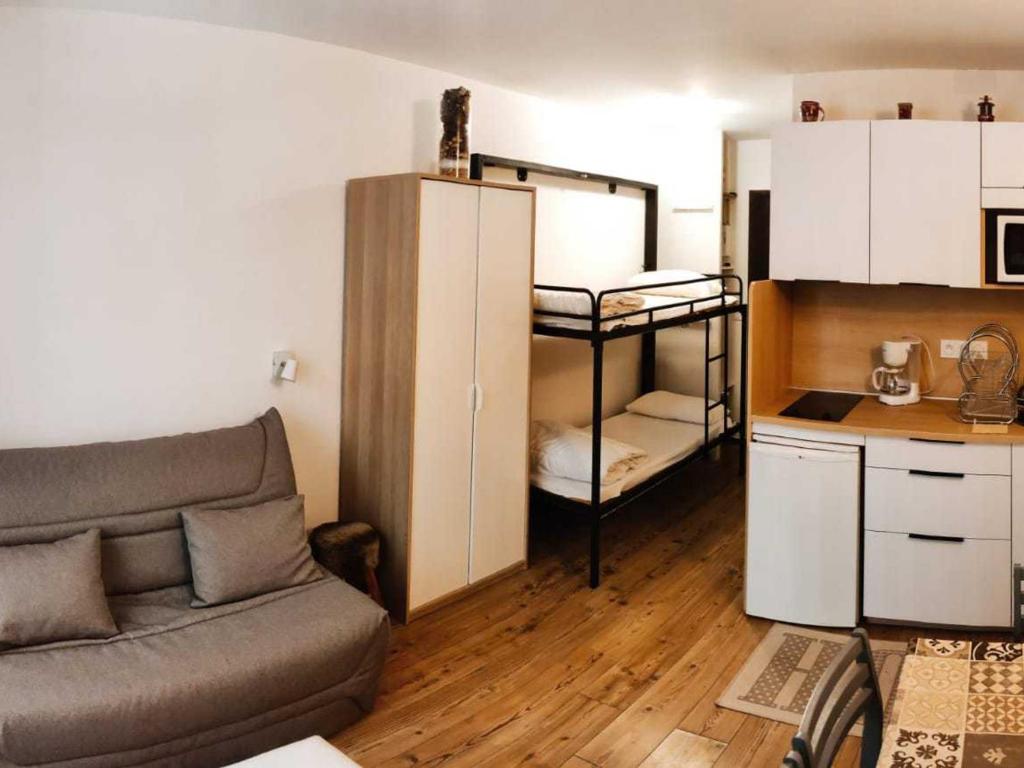 un salon avec un canapé et une petite cuisine dans l'établissement Studio cosy aux pieds des pistes avec balcon et coin montagne - La Joue du Loup - FR-1-504-621, à Saint-Étienne-en-Dévoluy
