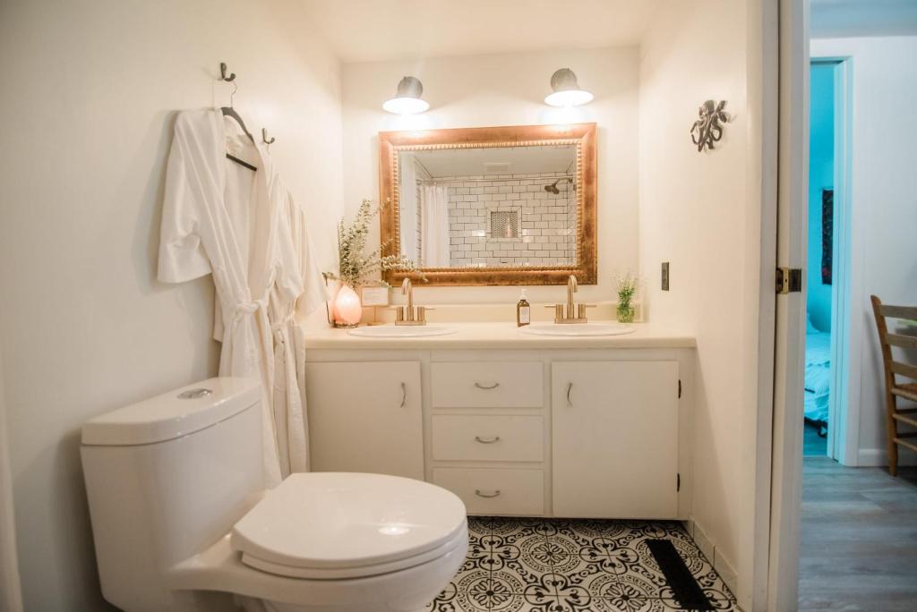 biała łazienka z toaletą i lustrem w obiekcie The Flat a Wanderlust Abodes property w mieście Central Lake