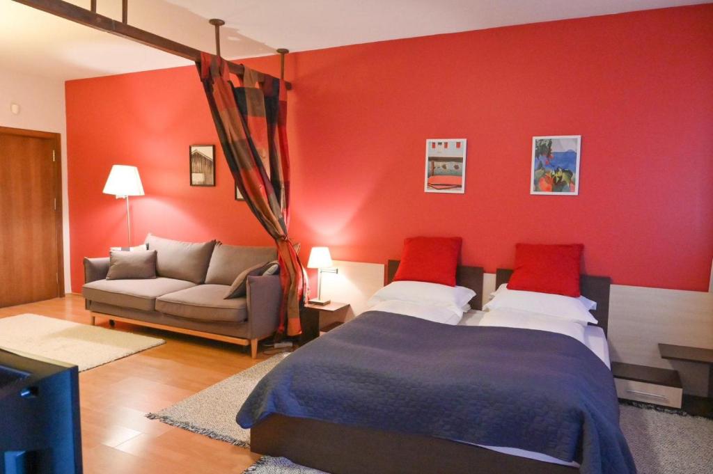 バンスコにあるCozy Fortuna Apartments 46の赤い壁のベッドルーム1室、ベッド1台、ソファが備わります。