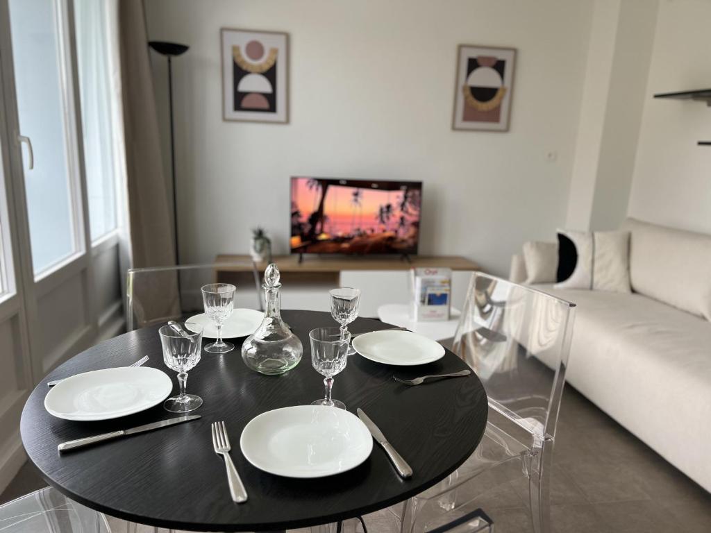 - une table noire avec des assiettes et des verres à vin dans l'établissement Le Duc de Guise, à Calais