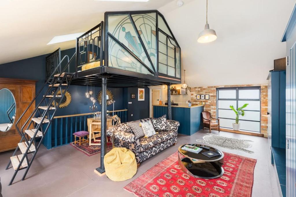 a living room with a loft bed and a couch at Pittville Loft Apartment - Central Cheltenham Highly Rated with Free Parking in Gloucestershire