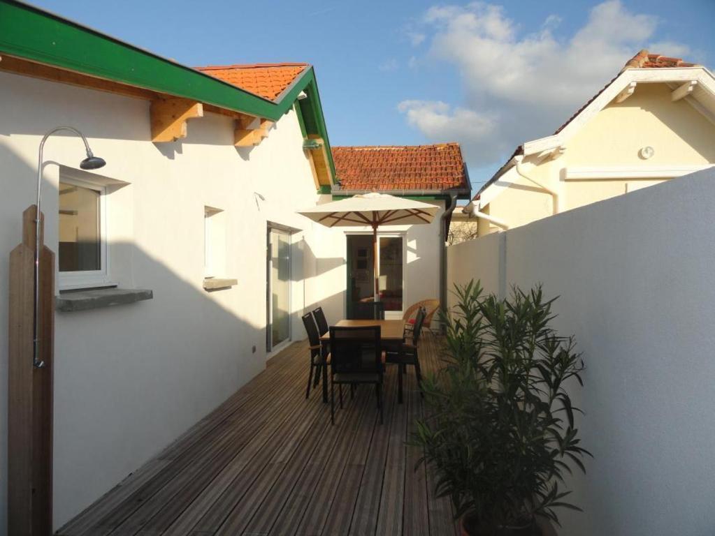 a patio with a table and chairs and an umbrella at Le rivage in Biscarrosse-Plage
