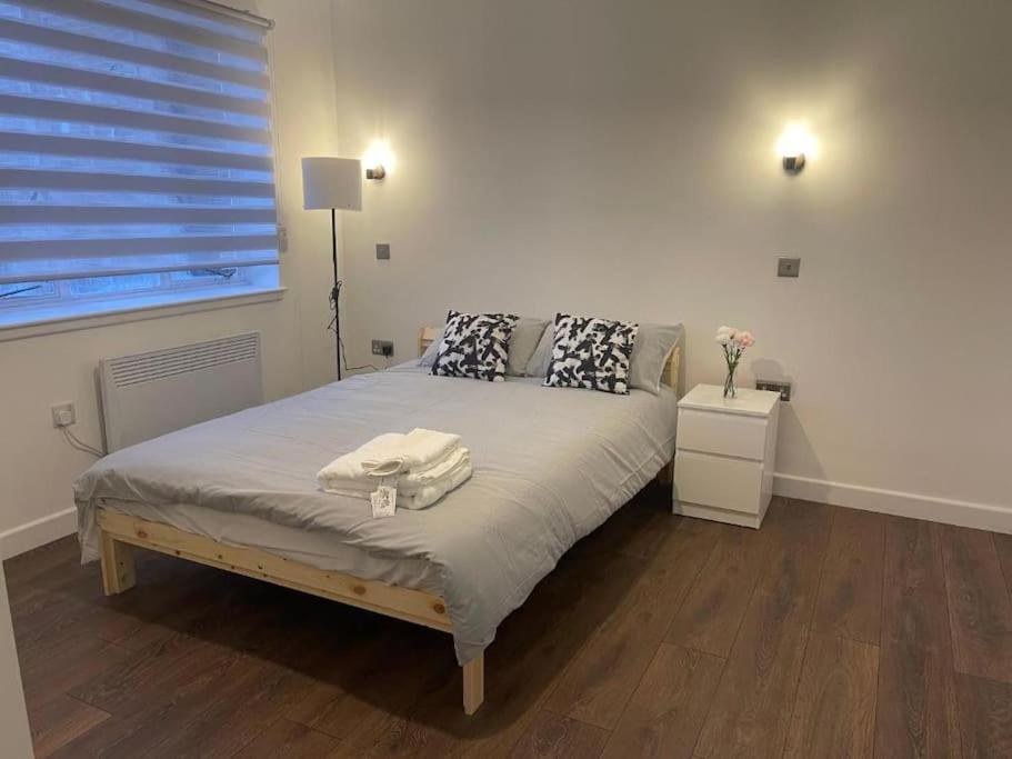 a bedroom with a bed with a lamp and a window at Aylesbury Apartment 3 with Parking in Buckinghamshire