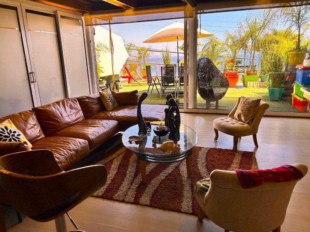 sala de estar con sofá, mesa y sillas en Apartamento Pacifico, en Viña del Mar