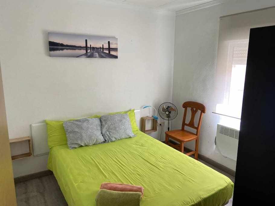 um quarto com uma cama verde e uma cadeira em Amplio con 2 dormitorios y muy equipado LA CANAL em Petrer