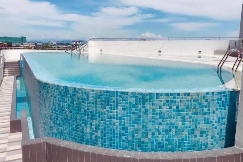 una piscina con azulejos azules en la parte superior de un edificio en V' BROS Deloft 2 Emporium Kuching, en Kuching