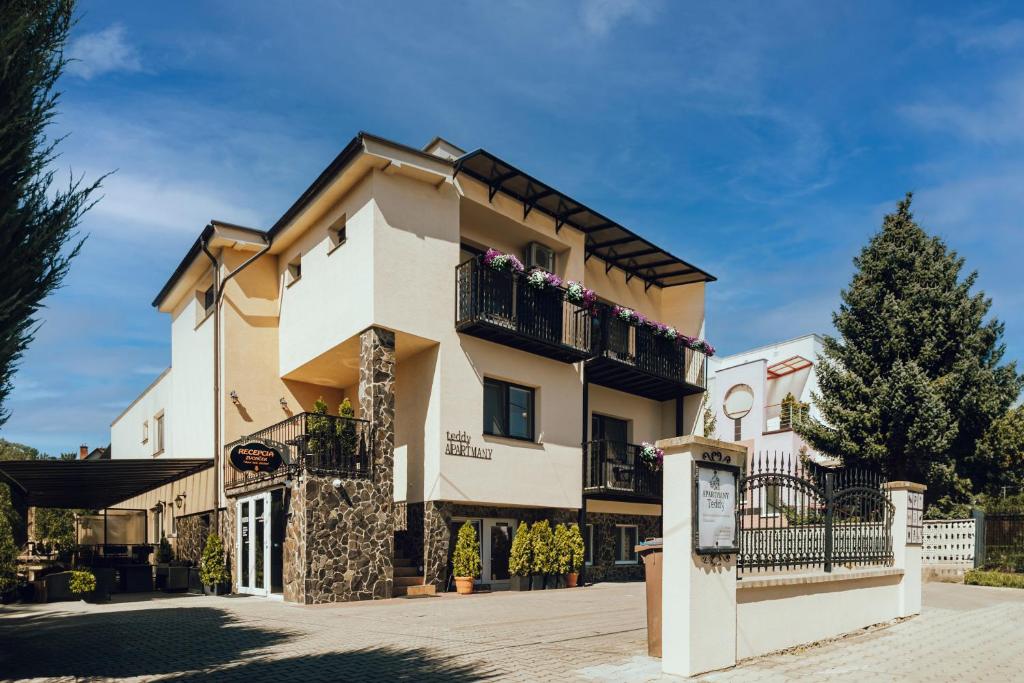 een groot huis met balkons in een straat bij Apartmány Teddy Bojnice in Bojnice