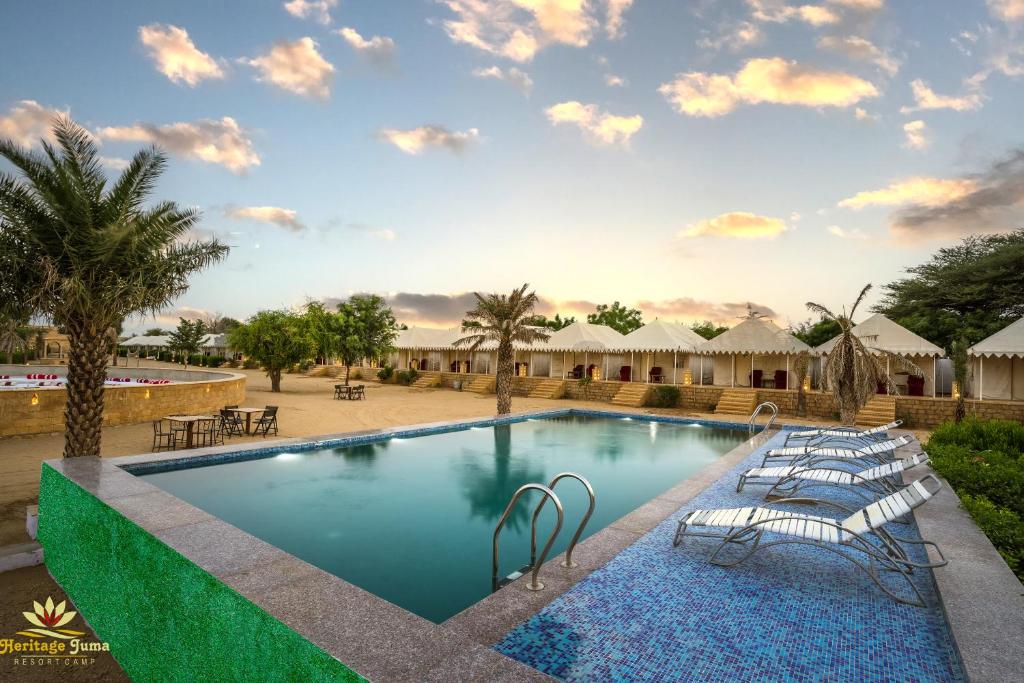 a pool at a resort with chairs and tables at Heritage Juma Resort with swimming pool in Jaisalmer