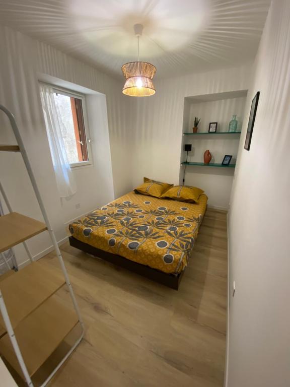 a bedroom with a bed and a ladder and a light at Appartement en bord de mer 1 in Banyuls-sur-Mer