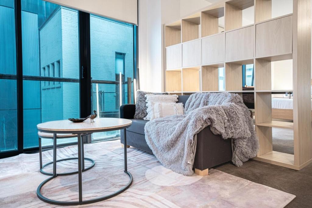 een woonkamer met een bank en een tafel bij Bourke St Mall 1br Studio Convenient Cosy Quiet in Melbourne