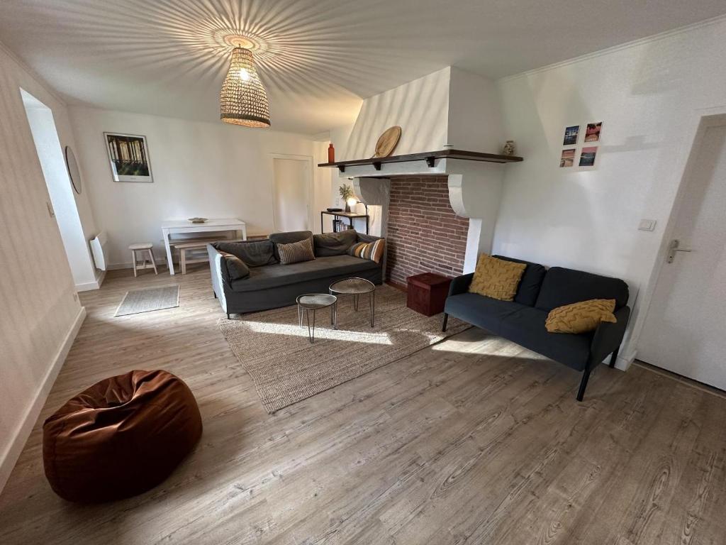 Una sala de estar con dos sofás y una chimenea. en Maison perouge, en Soustons
