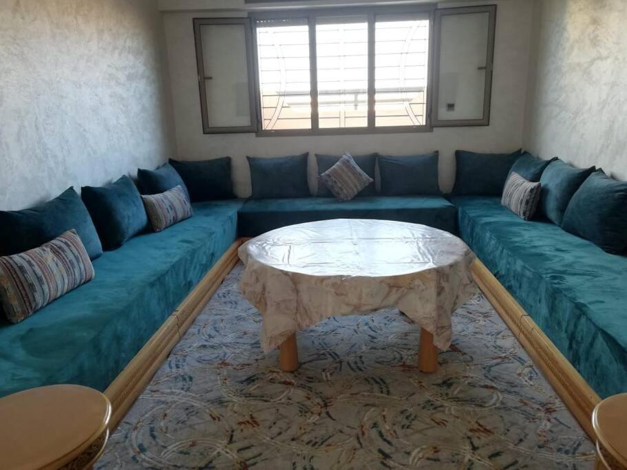 uma sala de estar com um sofá azul e uma mesa de centro em La Perle de L'ocean N03 RDC em Akhfennirr