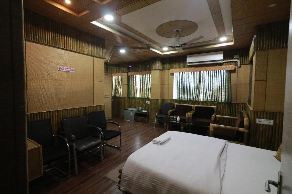 a room with a bed and chairs and a waiting room at Hotel Himalaya in Agartala