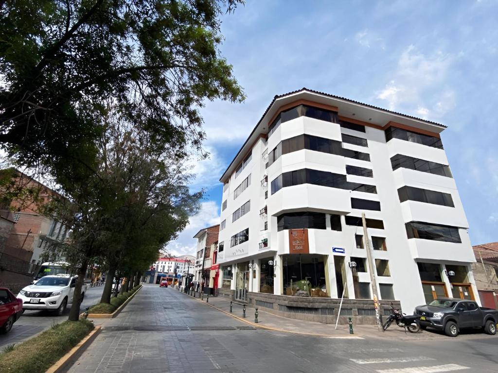 un edificio blanco al lado de una calle en Hotel El Puma, en Cusco